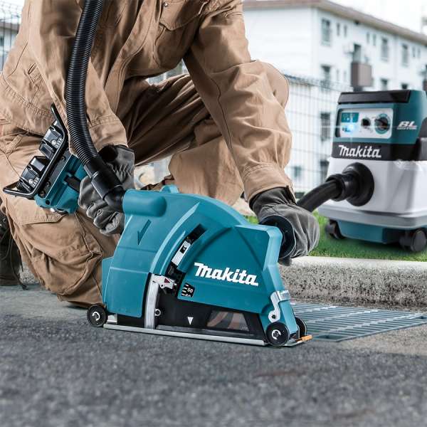工作人員使用 Makita DGA901ZU 充電式角向磨光機配集塵罩，並接駁充電式吸塵機於戶外路面切割