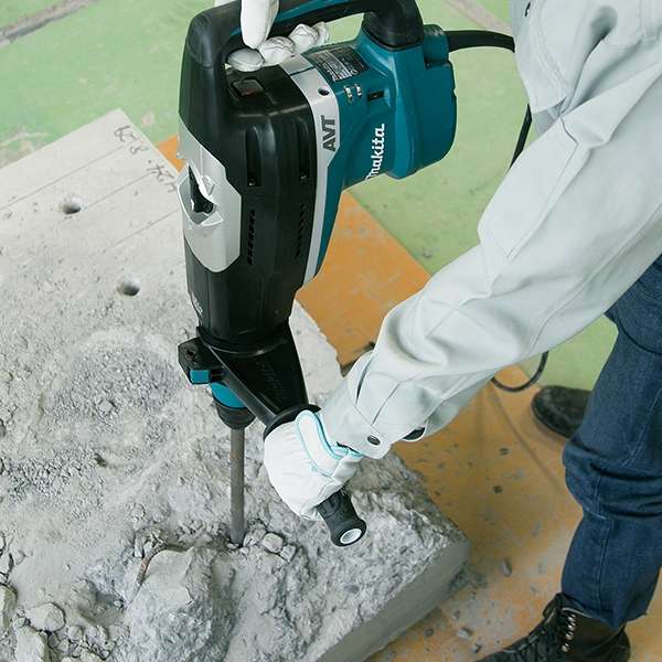 Worker chipping a concrete slab with the Makita HR5212C rotary hammer