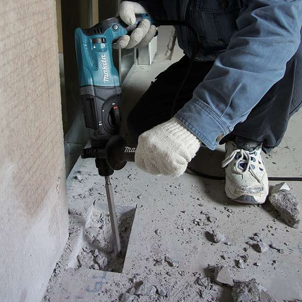 Worker using the Makita HR2470X5 combination hammer to chip a concrete floor