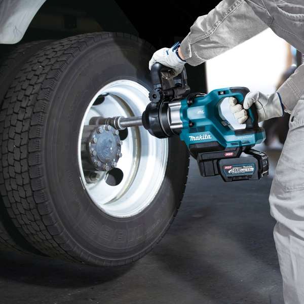 Worker using the Makita TW009GZ 40V cordless impact wrench on truck wheel nuts