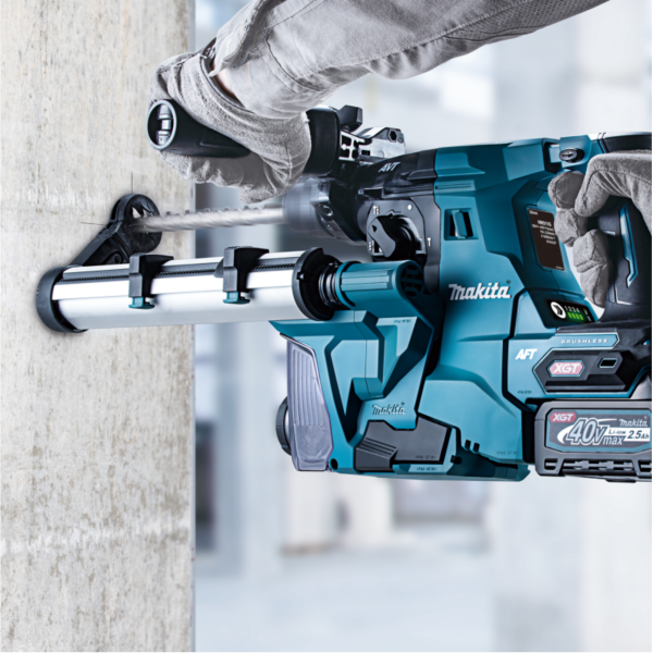 操作員手持 Makita HR011GZ 充電式電錘,配合集塵系統在混凝土牆面鑽孔