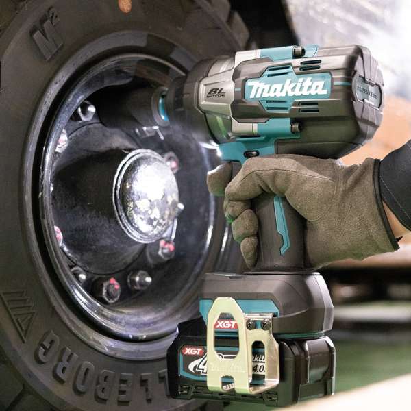 Makita TW002GZ 40V cordless impact wrench removing wheel nuts during vehicle servicing