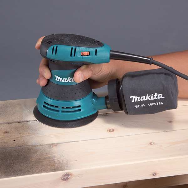 Makita 牧田 BO5031(110V) 平板軌道砂光機接上集塵袋，單手握持打磨木板表面