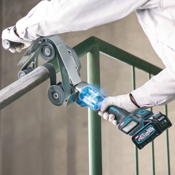 Worker using the Makita BS002GZ cordless pipe belt sander on a metal railing on site