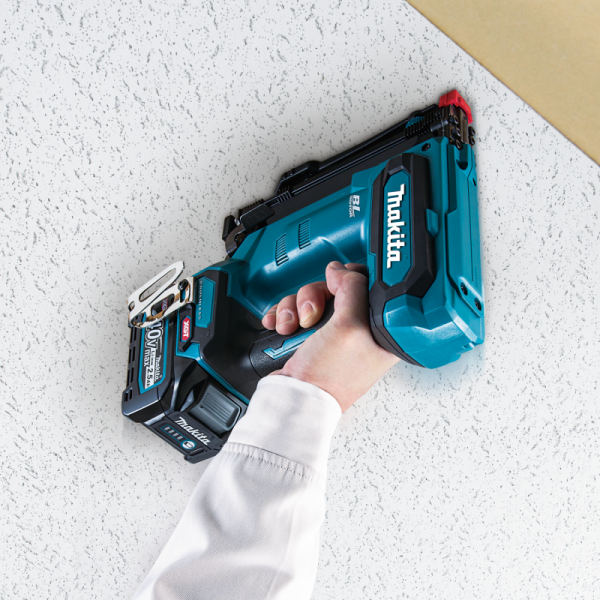以 Makita ST001GZ 充電式碼釘槍於批盪牆面單手進行固定作業