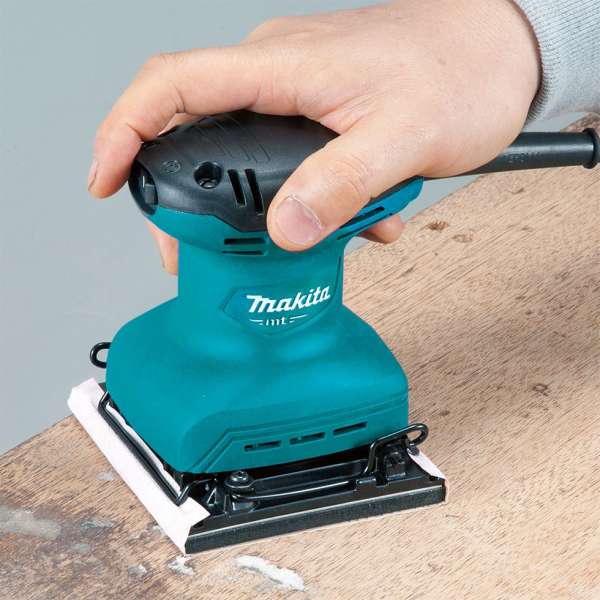 Makita 牧田 M9200B 平板砂光機單手握持，於木材表面進行打磨作業