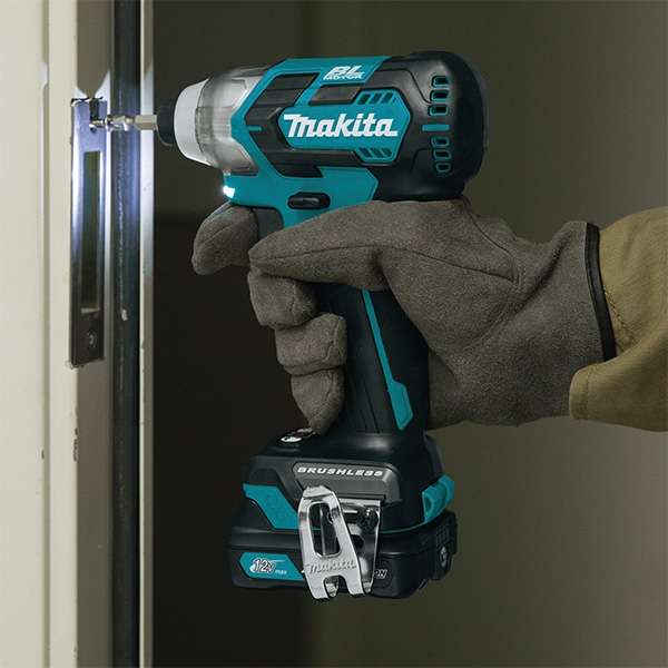 Gloved hand driving a screw into a door frame with the Makita TD111DSME 12V cordless impact driver