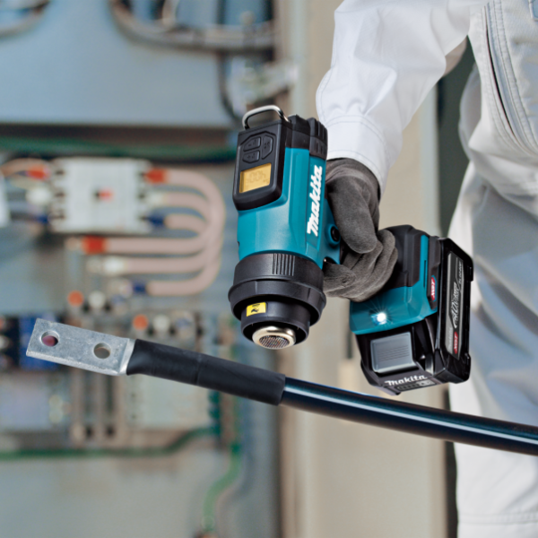 工作人員手持 Makita HG001GZ02 40V 充電式熱風槍，於電箱前為電纜熱縮套管加熱
