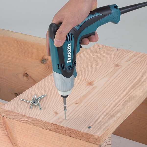 Makita TD0100(110V) impact driver driving a coarse thread screw into timber one-handed