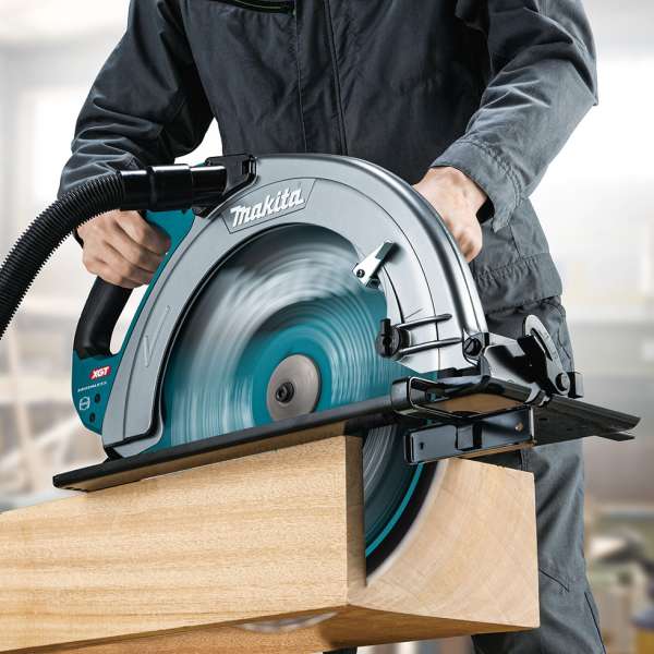 Operator cutting large-section timber with the Makita HS013GZ 40V cordless circular saw connected to a dust hose