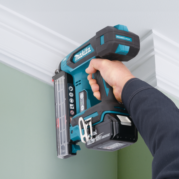 操作人員手持 Makita DBN501Z 充電式F針釘槍，於牆身頂部線條位置打釘