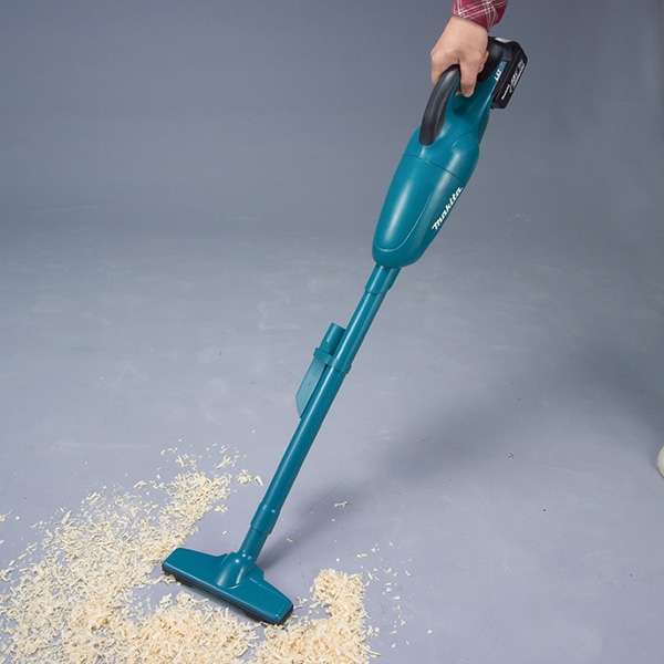 DCL180 series cordless vacuum cleaner picking up wood shavings from a floor