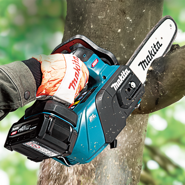 Makita UC031GZ 40V cordless chain saw cutting a tree trunk one-handed on site