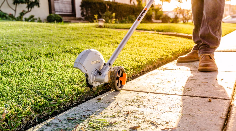 WORX WA0223 lawn edger attachment cutting a straight lawn edge along a walkway (power head not included)