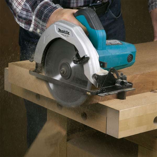 工作人員使用 Makita M5801B 電圓鋸在工作台上切割木材