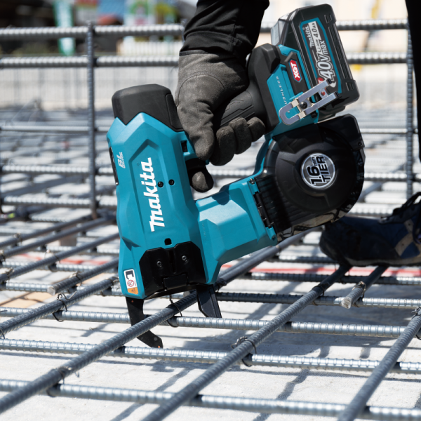 Worker tying crossed rebar on a site mat with the Makita TR001GZ cordless rebar tying tool