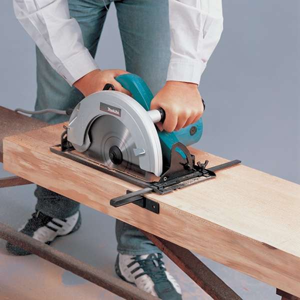 工作人員手持 Makita N5900B 電圓鋸，在工作架上鋸切木樑