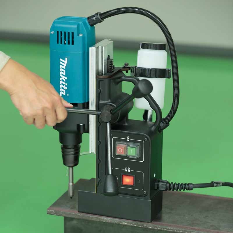 Makita 牧田 HB350 磁力鑽吸附於鋼材上，操作員轉動進給手柄鑽孔，機身裝有冷卻液樽