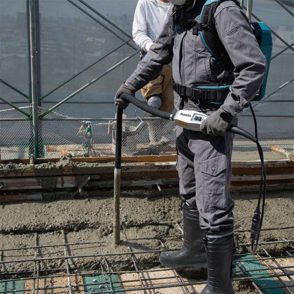 工人在工地使用 Makita VR003CZ 充電混凝土振盪器搗實新澆築的混凝土