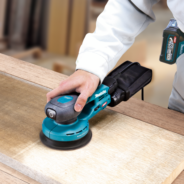 Operator sanding a timber surface with the Makita BO002CGZ 40V random orbit sander