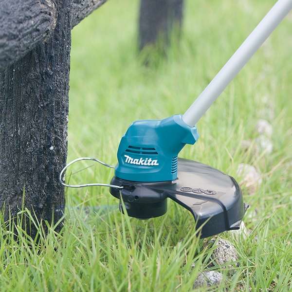 Makita UR100DZY 充電式割草機的尼龍頭在樹幹周圍修邊