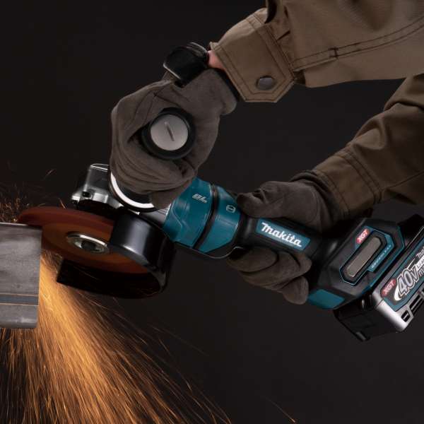 Makita GA051GZ 40V cordless angle grinder throwing sparks while grinding steel on site