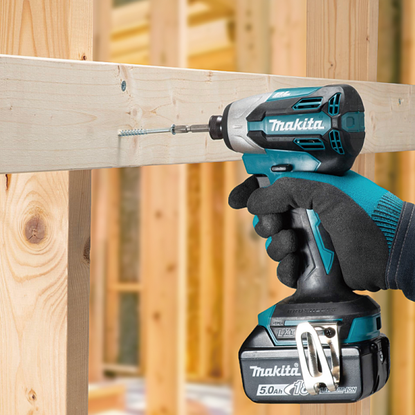 Makita DTD158Z cordless impact driver driving a screw into timber framing