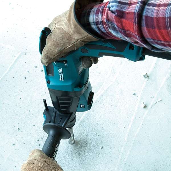 Operator drilling into a concrete wall with the Makita HR2630X6 combination hammer