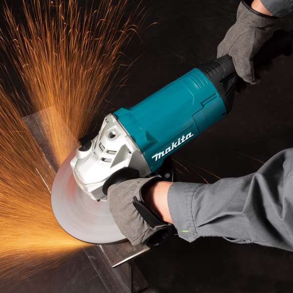 操作人員雙手握持 Makita GA9081 角向磨光機切割金屬並產生火花的實際作業情境