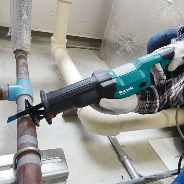操作人員手持 Makita M4500KB 往復鋸於室內切割金屬管道