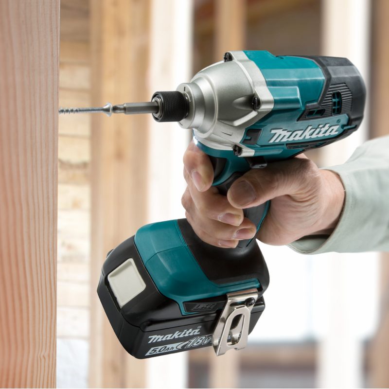 Makita DTD156SFE cordless impact driver being used to drive a screw into timber framing