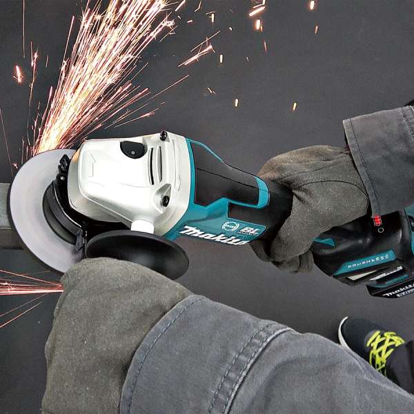 工人手持 Makita DGA418ZU 充電式角向磨光機進行金屬切割，火花四濺