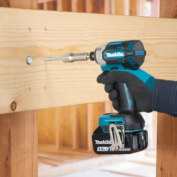Makita DTD201RTJ 18V cordless impact driver driving a screw into timber framing