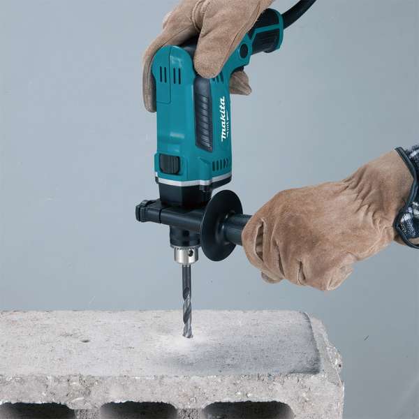 Operator using the Makita M8103B hammer drill with side handle fitted to drill into a concrete block