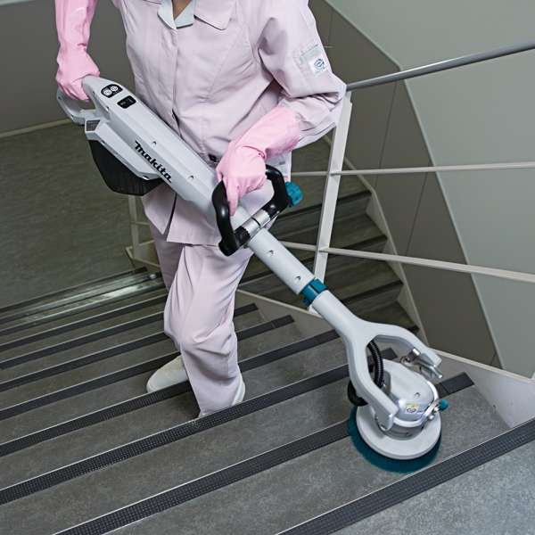 操作人員使用 Makita PS001GZ 充電式拋光洗地機清潔樓梯級面