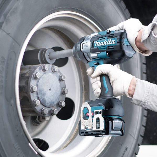 Operator using the Makita TW011GZ 40V cordless impact wrench on truck wheel nuts