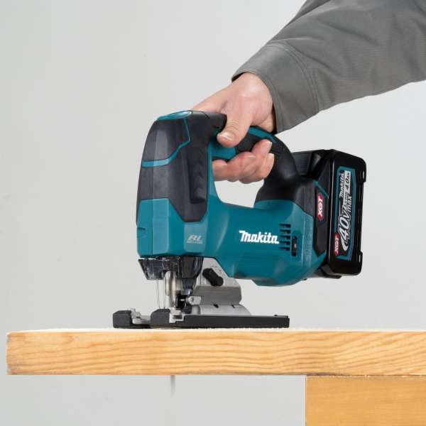 Makita JV002GM201 40V max cordless jig saw cutting a timber board one-handed