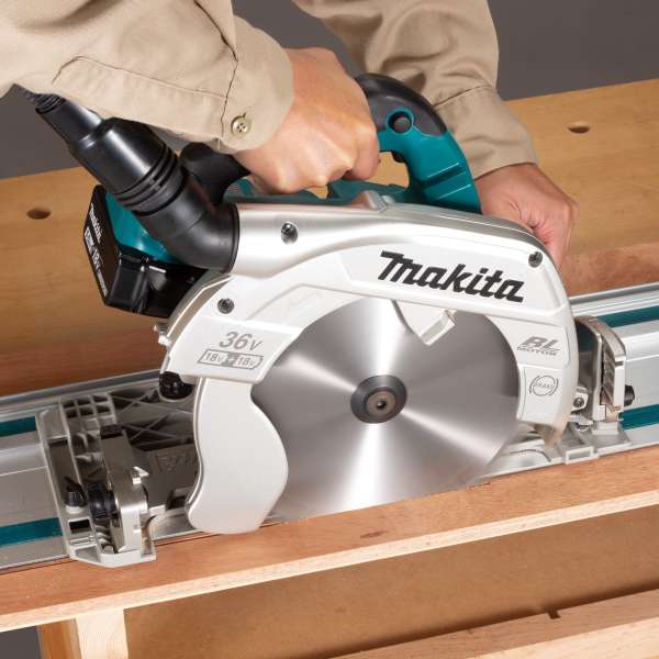 Makita DHS900Z cordless circular saw cutting a board along a guide rail