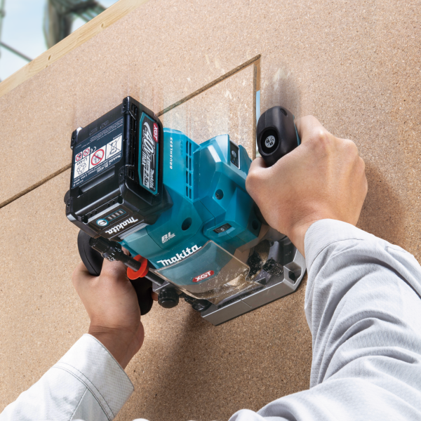 操作人員雙手握持 Makita RP001GZ 40V 充電式電木銑於木板上開槽