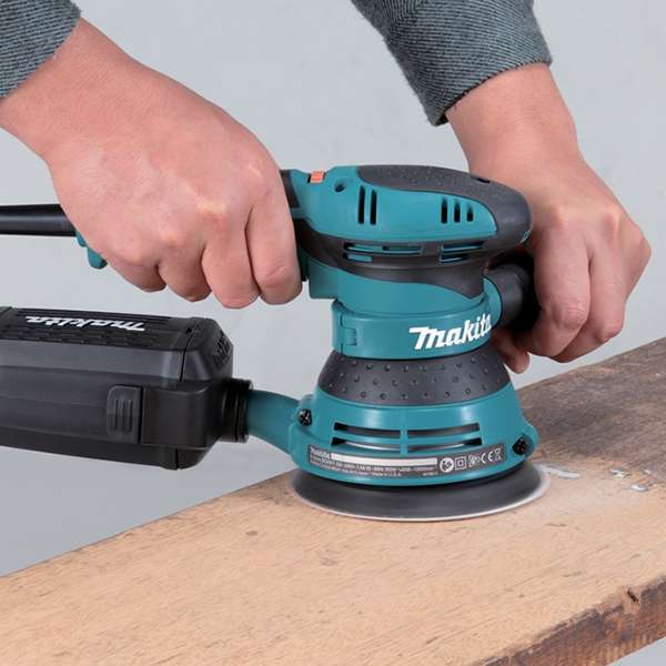 雙手操作 Makita BO5041 平板軌道砂光機打磨木板表面