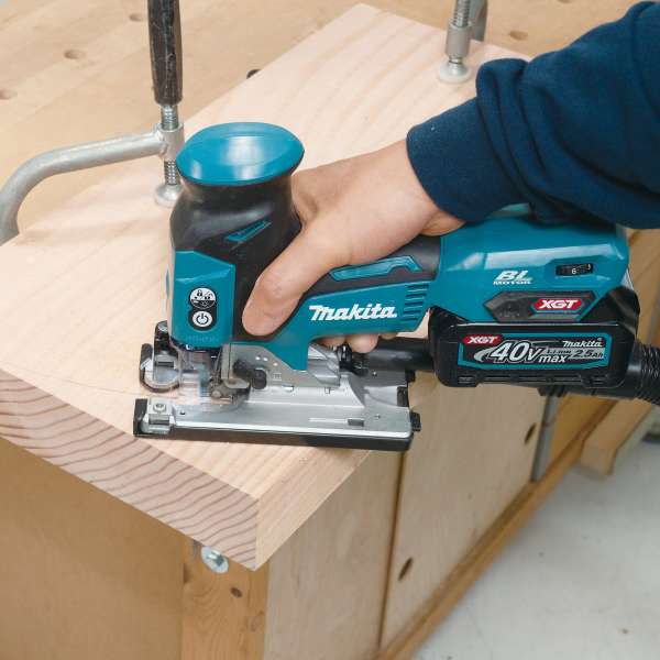Makita JV001GZ 40V cordless jig saw cutting a wooden board