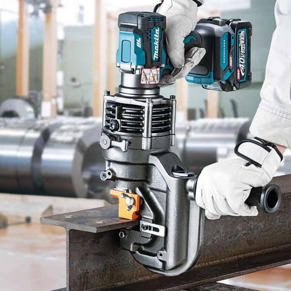 工作人員雙手持握 Makita PP001GZK 充電式金屬沖孔機,於工場內鋼材上進行沖孔作業