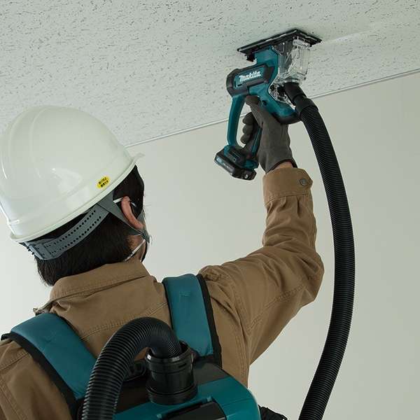 工人配合背負式集塵機使用 Makita SD100DZ 充電式石膏板切斷機進行天花開孔作業