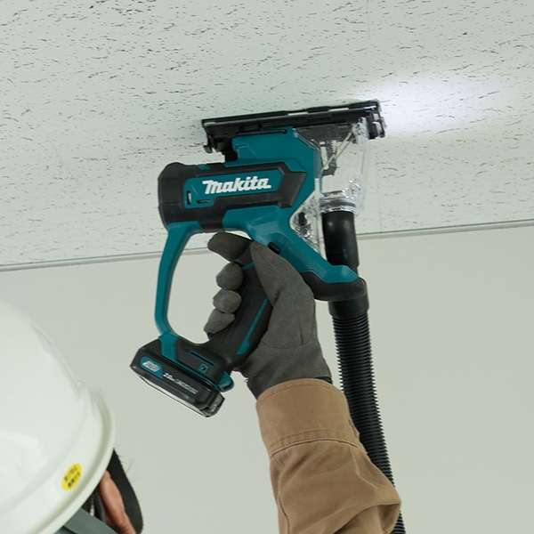 以 Makita SD100DZ 充電式石膏板切斷機單手在天花石膏板上切割,並已接駁集塵喉管