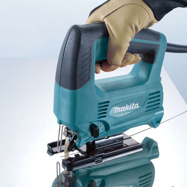 Operator using the Makita M4301B jig saw to cut a board
