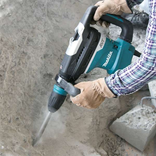 Worker using the Makita HR4013C rotary hammer to chip a concrete floor