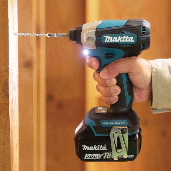 Worker driving a coarse thread screw into a timber stud with a Makita DTD157Z 18V cordless impact driver, built-in job light switched on